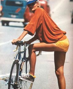 a woman riding a bike down a street