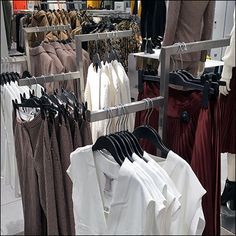 clothes are hanging on racks in a clothing store