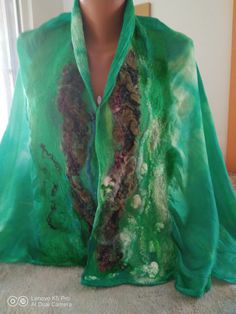 This is scarf is made from fine italian silk as a base, and fine merino wool. The method is wet felting - I use only soap and water. It is very easy to care about this scarf - only not wash in a washing machine. The size is about 175/ 75 cm. Handmade Bohemian Green Silk Scarf, Handmade Green Bohemian Silk Scarf, Handmade Wool Scarf, Nuno Felted Scarves, Wool Cape Coat, Felt Scarf, Artistic Hand-dyed Green Scarves, Handmade Scarf, Wool Cape