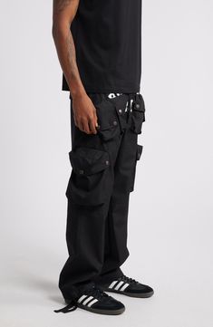 These cotton-blend cargo pants have an array of pockets and a slouchy silhouette for a streat-ready look. 30 1/2" inseam; 18" leg opening; 13" front rise; 16" back rise (size Medium) Elastic/drawstring waist Front snap-patch pockets; cargo snap-patch pockets; back decorative pocket flaps Lined 63% cotton, 37% nylon Hand wash, dry flat Imported Black Owned/Founded Heat Index, Billionaire Boy, Billionaire Boys Club, Fabric Gift Bags, Fabric Gifts, Nordstrom Store, Free Fabric, Black Fits, Cargo Pants