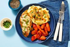 a blue plate topped with chicken, carrots and mashed potatoes