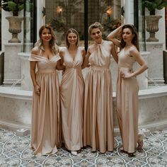 four bridesmaids pose for a photo in front of a fountain