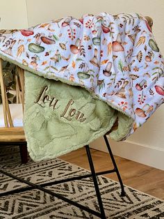 a baby blanket sitting on top of a wooden chair