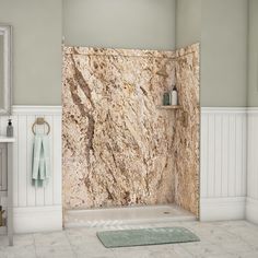 a bathroom with marble walls and flooring in the shower area, along with a rug on the floor