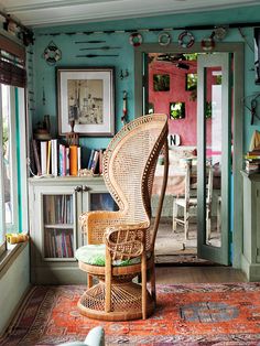 a room with blue walls and wicker chairs in the corner, an area rug on the floor