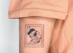 a woman's arm with a stamp on it that has a drawing of a girl holding a baby