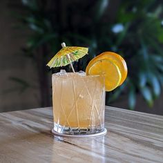 an orange cocktail garnished with an umbrella