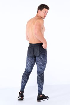 a man with no shirt on is standing in front of a white background wearing black and blue patterned leggings