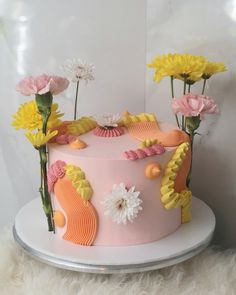 a pink cake with yellow flowers on top