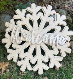 a wooden snowflake with the word welcome on it