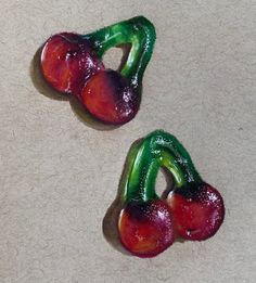 two pieces of fruit sitting on top of a white counter covered in green and red jello