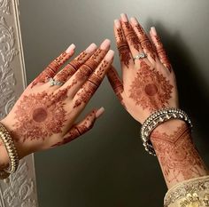 two hands with hendi tattoos on their palms are shown in front of a mirror