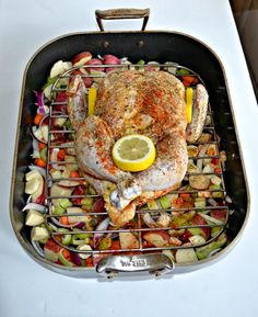 a chicken on a grill with vegetables and lemon