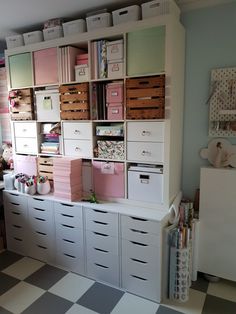 a room filled with lots of drawers next to a wall mounted bookcase and desk