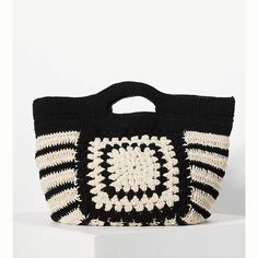 a black and white crocheted bag sitting on top of a table