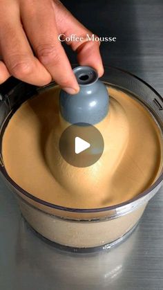 someone is mixing something in a bowl with a blender on the side and their thumb pointing at it