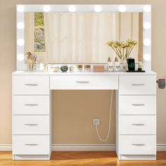 a white vanity with lights on top of it