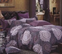 a bed room with a neatly made bed and purple comforter