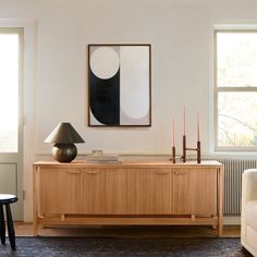 a living room with a large painting on the wall next to a table and chair