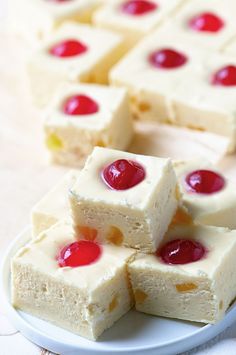 four pieces of cake on a plate with cherries