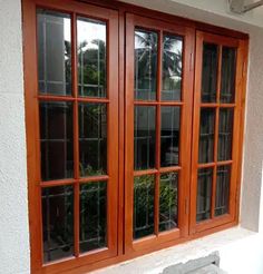 a window with wooden frame and glass panes on the side of a white building