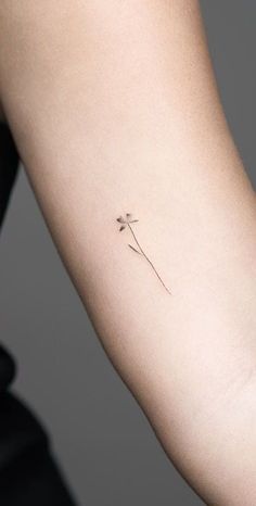 a single flower tattoo on the arm