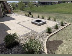 a stone fire pit in the middle of a yard