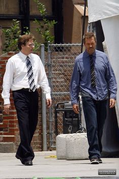 two men in ties walking down the street