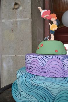 there is a three layer cake decorated with figurines