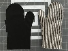 two black gloves sitting on top of a cutting board