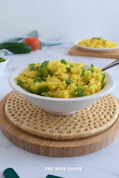 a white bowl filled with rice and broccoli on top of a wooden cutting board