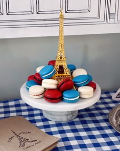 there is a plate with french macaroons on it and the eiffel tower in the background