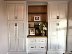 an empty room with white cabinets and drawers