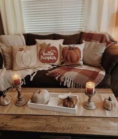 a living room filled with lots of pillows and candles on top of a coffee table