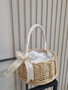 a wicker basket with a white ribbon tied around it and a sign that says happy birthday