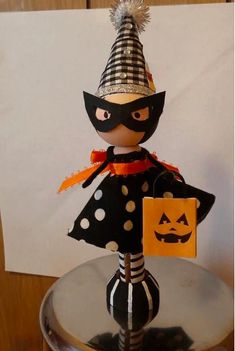 the doll is wearing a black and white polka dot dress with a mask on it's head