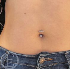 a woman's stomach with a diamond ring on the end of her tummy