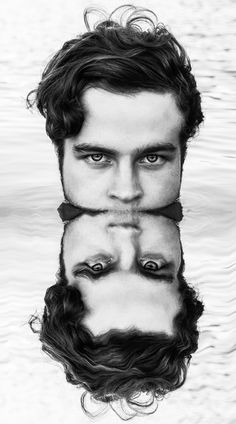 a man's face is reflected in the water with his hands on his hips