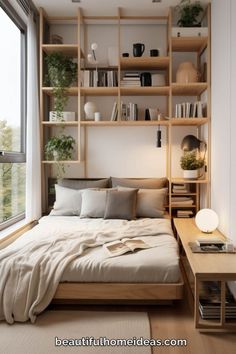 a bed sitting under a window next to a wooden shelf filled with books and plants