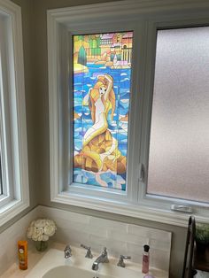 a bathroom sink under a stained glass window