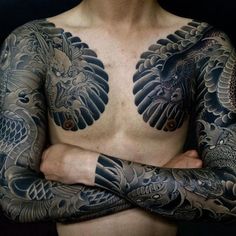 a man with tattoos on his chest and arms