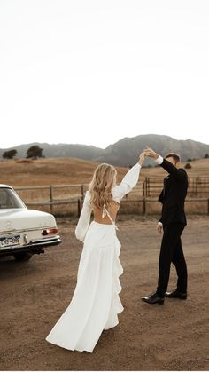 a bride and groom dancing in the dirt