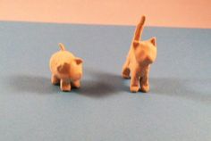 two small plastic cats on a blue surface