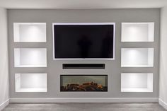 a flat screen tv mounted to the side of a wall next to a fire place