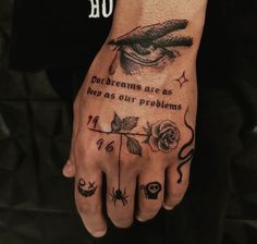 a person's hand with some tattoos on it