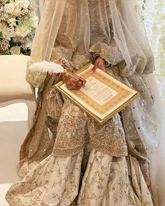 a woman in a wedding dress is holding a framed paper with an inscription on it