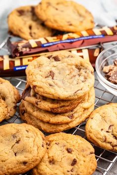 chocolate chip cookies on a cooling rack with candy bars in the background