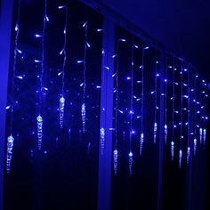 blue lights are hanging from the side of a window