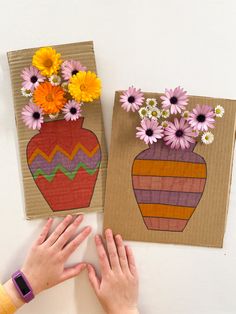 two handmade cards with flowers in vases on the left and right sides, one being held up by someone's hands