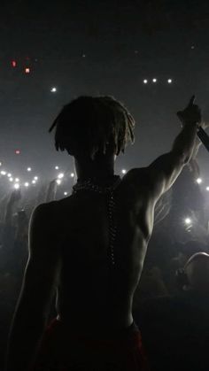 a man with dreadlocks standing in front of a crowd